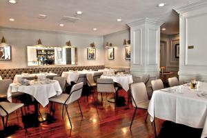 a dining room with white tables and chairs at Club Donatello in San Francisco