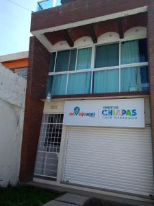 um edifício com uma porta de garagem e um sinal nele em Terraza Tuxtla em Tuxtla Gutiérrez