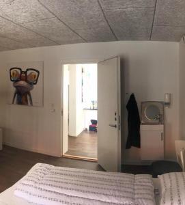 a bedroom with a bed and a door to a hallway at Grindsted - Billund Apartment 1 in Grindsted