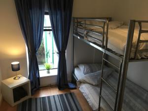 a bedroom with two bunk beds and a window at Danny’s Place in Derry Londonderry
