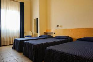 Zimmer mit 3 Betten und einem Fenster in der Unterkunft Albergo Ristorante Saverino in Valderice