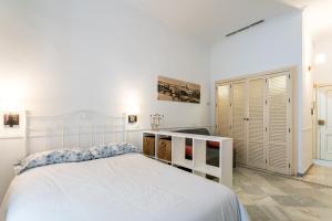 セビリアにあるHolidays Isbilia Centroの白いベッドルーム(白いベッド1台、クローゼット付)