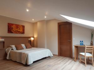 a bedroom with a bed and a desk with a chair at La Chopera in Ribadesella