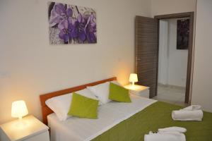 una camera da letto con un letto con cuscini verdi e bianchi di Green Residence a Rimini