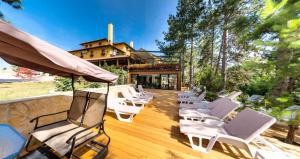 een groep stoelen op een houten terras bij Hotel Borkovac in Ruma