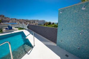a swimming pool on the roof of a house at Hostal Casa Mercedes in Nerja
