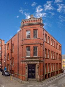 a large red brick building on a street at Stylish and comfortable Lace Market Studio Apartment in Nottingham