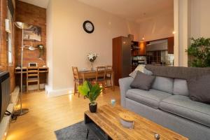 ein Wohnzimmer mit einem Sofa und einem Tisch in der Unterkunft Stylish and comfortable Lace Market Studio Apartment in Nottingham