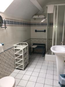 a bathroom with a toilet and a sink at Hôtel d'Arromanches Pappagall in Arromanches-les-Bains