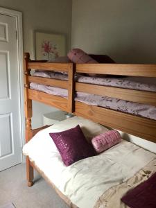 a bedroom with two bunk beds with purple pillows at Beautiful Family Home in Greyabbey