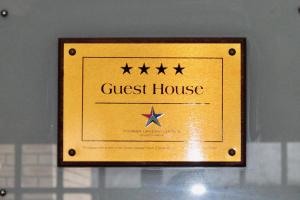 uma placa de casa de hóspedes dourada com quatro estrelas em House and Heart Guest House em Vanderbijlpark