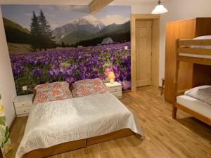 ein Schlafzimmer mit einem Wandbild aus einem Feld lila Blumen in der Unterkunft Domek pod Maciejową in Rabka-Zdrój