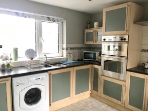 a kitchen with a washer and a dishwasher at Beautiful Family Home in Greyabbey