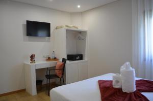 a hotel room with a bed and a desk with a computer at Domus Graciosa in Ponte de Lima