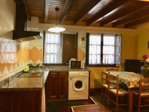 a kitchen with a stove and a washing machine at Apartamentos Palombina in Celorio