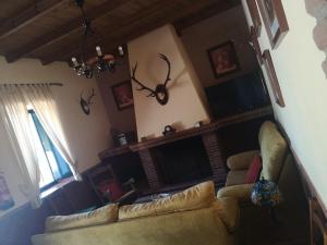 sala de estar con sofá y chimenea en CASA RURAL LA DEHESILLA, en Cazalla de la Sierra