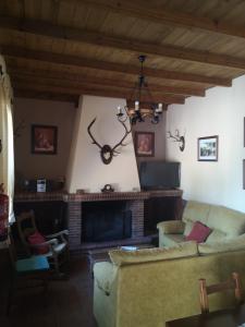 sala de estar con sofá y chimenea en CASA RURAL LA DEHESILLA, en Cazalla de la Sierra