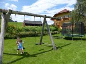 a little girl playing on a swing in a yard at Ferienhaus Wohleser in Mariahof