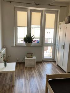 an empty living room with two windows and a table at Centrum Apartament in Gdańsk