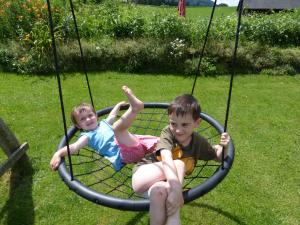 two young children sitting in a swing at Ferienhaus Wohleser in Mariahof