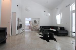 a living room with a black couch and a tv at Bungalow 4 Suns in Virpazar