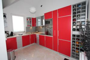 a kitchen with red cabinets and a window at Bungalow 4 Suns in Virpazar