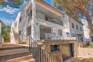 a white building with stairs leading up to it at Llafranc Centre, Totally Refurbished in Llafranc