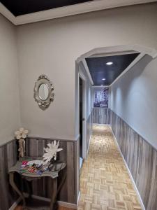 a hallway with a mirror on the wall and a table at Apartamentos Avenida de La Paz in Logroño