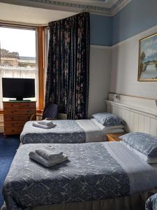 a hotel room with two beds and a television at Woodlea in Perth