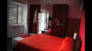 a bedroom with a red bed and a mirror at La Pinetina Roma in Rome