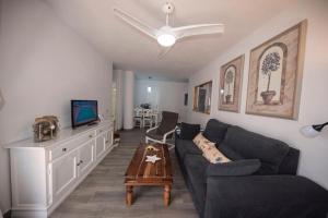 een woonkamer met een bank en een tv bij Atlanterra Sol in Zahara de los Atunes