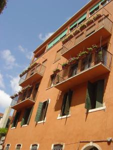 een hoog oranje gebouw met balkons en planten erop bij Guesthouse Alloggi Agli Artisti in Venetië