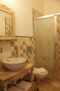 a bathroom with a sink and a toilet and a shower at Ciftekuyu Hotel in Alaçatı