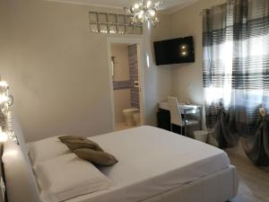 a bedroom with a bed and a desk and a television at La Finestra sul Mare in Letojanni