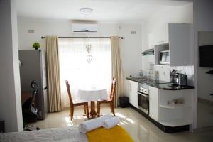 a small kitchen with a table and a window at Mt Pleasant B'n'B in Harare