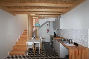 een keuken met een tafel en stoelen en een trap bij Oporto City Cottage in Porto