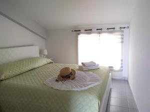 a bedroom with a bed with a hat on it at CentroCittà Beach in Roccalumera