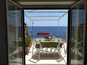 a table and chairs on a balcony with a view of the ocean at CentroCittà Beach in Roccalumera