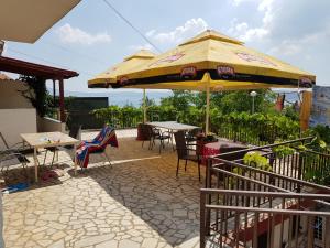 a patio with an umbrella and tables and chairs at Apartment Katica in Crikvenica