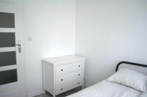 een slaapkamer met een bed en een witte dressoir bij Apartment Mostek 5 minutes walk from the Old Town in Gdańsk