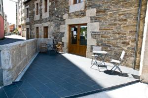 a patio with chairs and a table in front of a building at PENSION SERRANO in Sarria