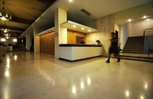 a man walking through a lobby with a counter at Zikas Hotel in Preveza