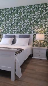 een slaapkamer met een wit bed met groen en wit behang bij The Old Town House in Faro