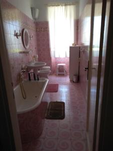 a bathroom with two toilets and a sink and a tub at La casa dei Fiori in Vetralla