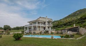 a large house with a pool in front of it at Villa Virginia in Vonitsa