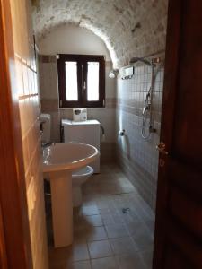 アルベロベッロにあるAlberobello Casa Vacanze - Pathos tra i Trulliのバスルーム(洗面台、トイレ付)、窓が備わります。