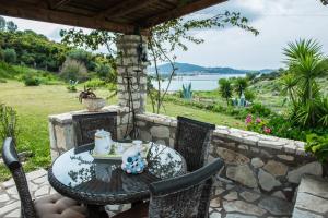 a table and chairs on a patio with a view of the water at Villa Virginia in Vonitsa
