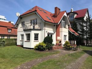una casa bianca con il tetto rosso di Dom Przy Plaży a Mielno