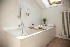 a white bathroom with a tub and a shower at Apartment JoniFee am Titisee in Titisee-Neustadt +23 photos