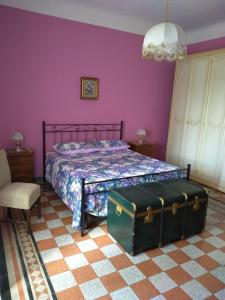 a bedroom with a bed with purple walls at La casa dei Fiori in Vetralla
